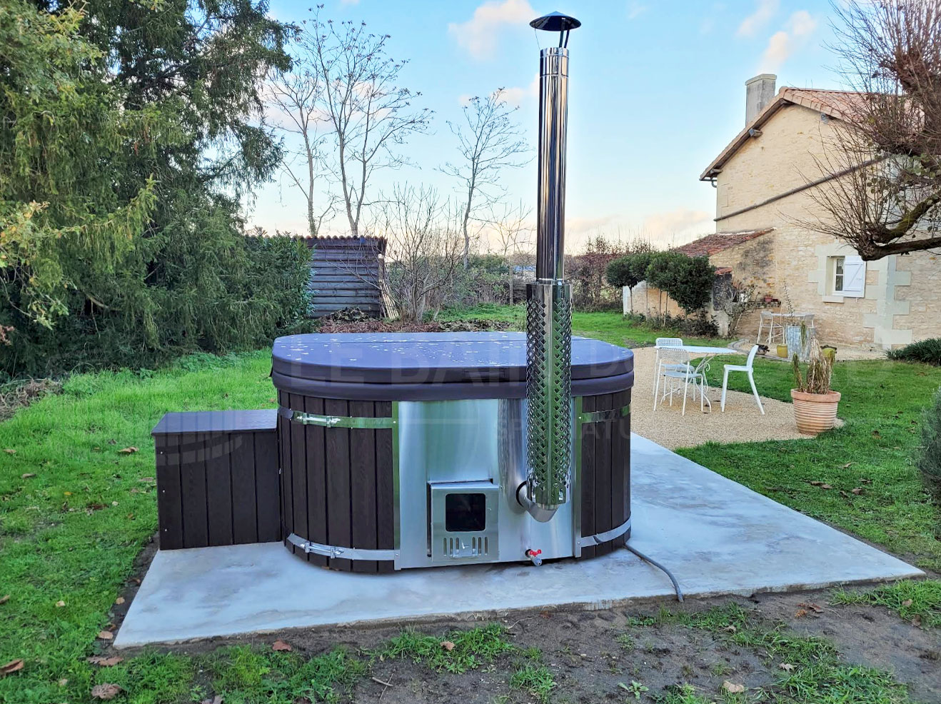 bain nordique carré noir sur une dalle béton dans un beau jardin